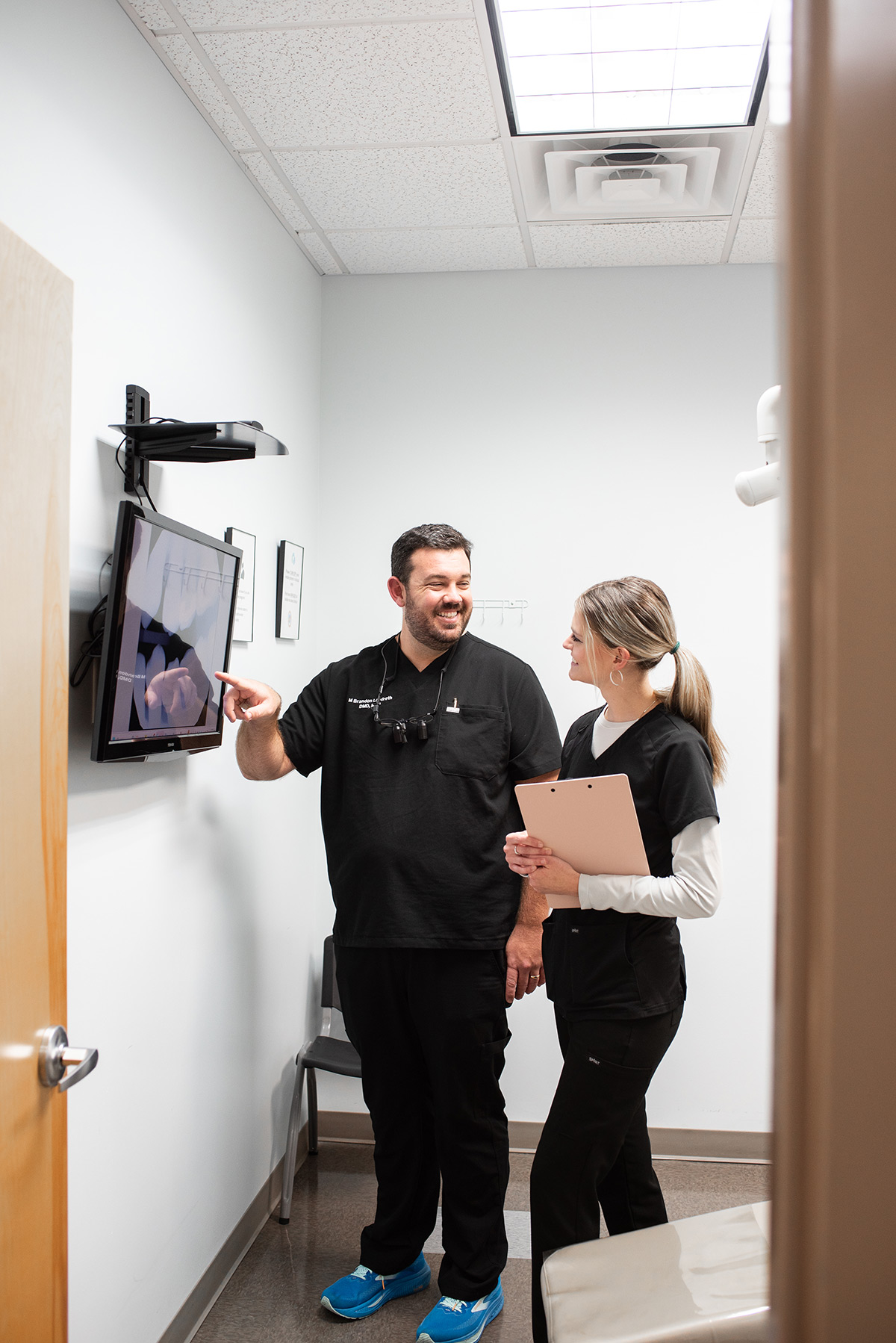 Carolina Roots Dental team member reviewing dental images with a patient